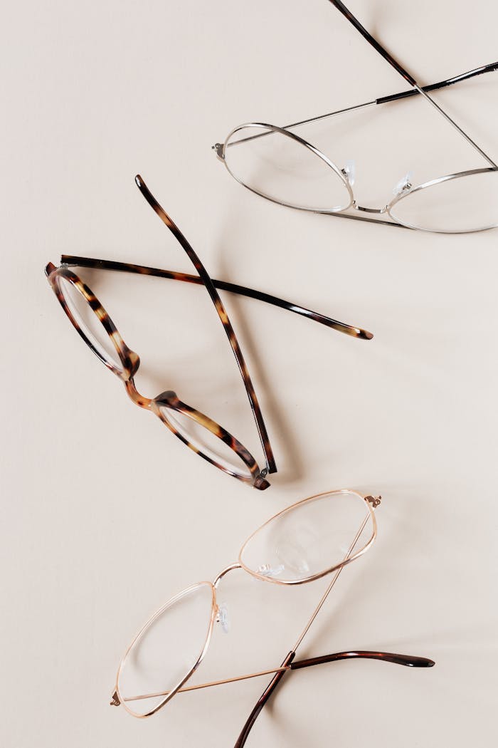 Elegant collection of diverse eyeglasses displayed on a beige surface, perfect for fashion and optical themes.